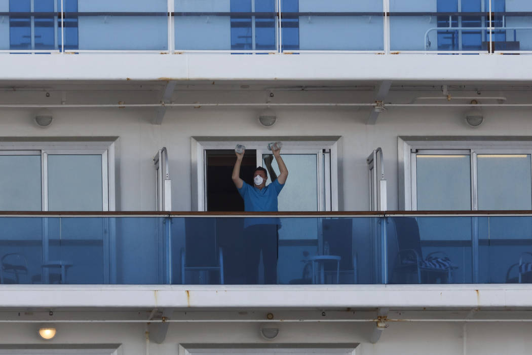 A passenger exercises using two water bottles on the quarantined Diamond Princess cruise ship W ...