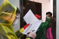 In a Feb. 18, 2020, photo released by Xinhua News Agency, workers go door to door to check the ...