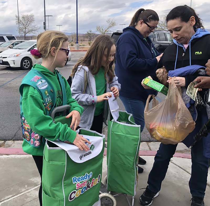 Girl Scouts sell cookies to those attending the Nevada Democratic caucuses at Sierra Vista High ...