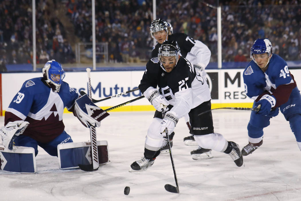 Los Angeles Kings defenseman Alec Martinez, center, looks to redirect the puck, between Colorad ...