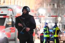 A police officer stands guard near the scene in front of a restaurant after a shooting in centr ...