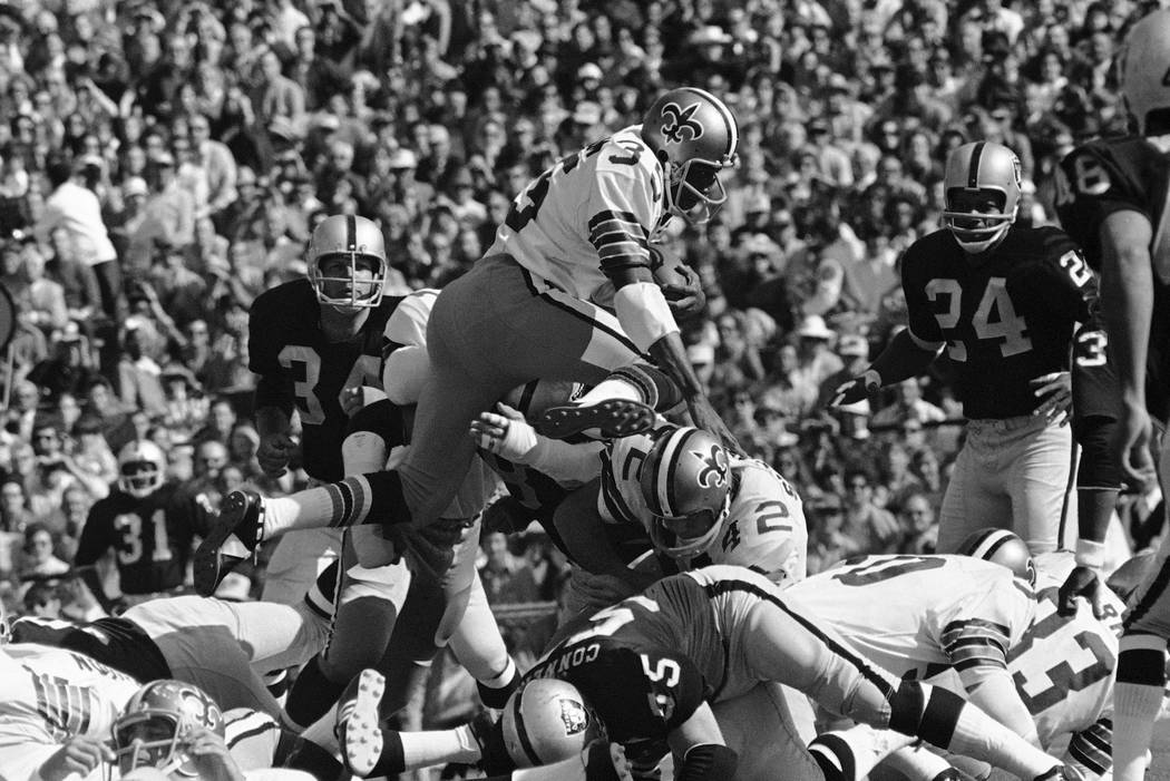 New Orleans Saints running back Bob Gresham (35) takes to the air for a first down over teammat ...