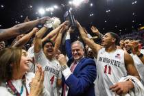 San Diego State head coach Brian Dutcher, center, and players hold up the Mountain West Champio ...