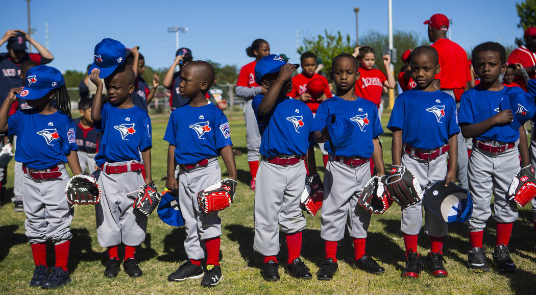Members of the Blue Jays put their hats back on after the national anthem during the opening da ...
