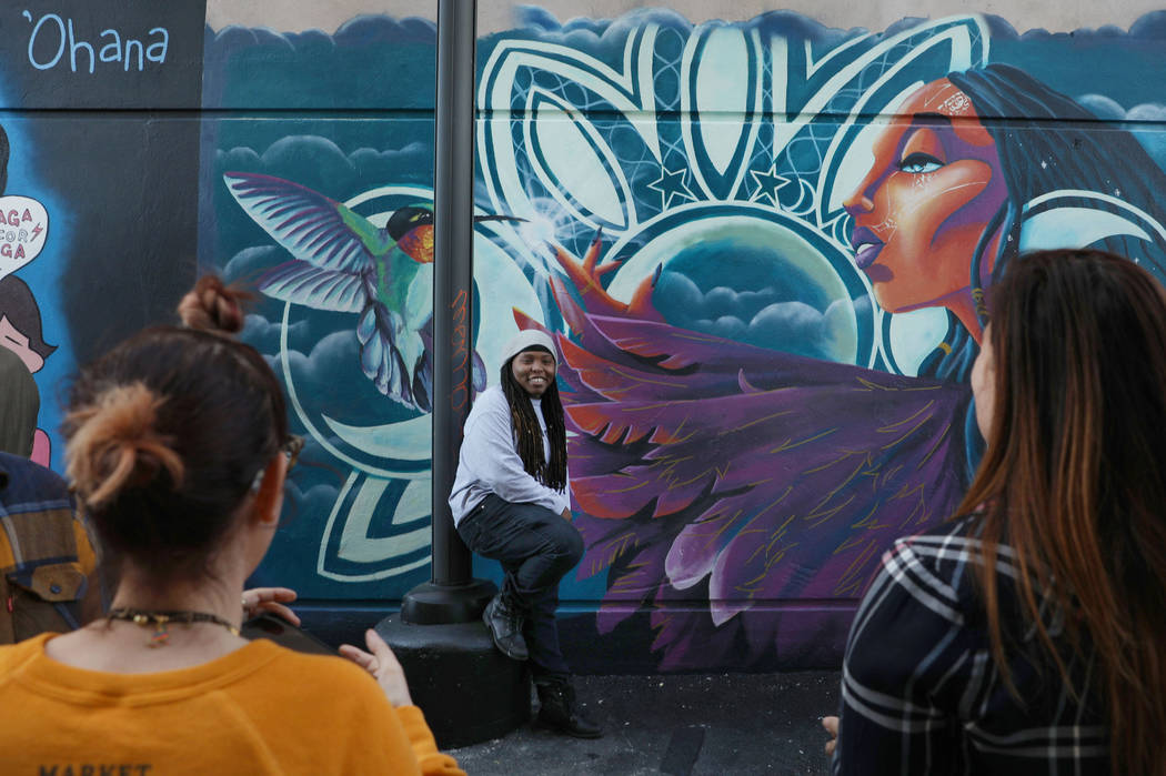 Local painter Sloane Siobhan is photographed in front of her mural during the grand opening of ...