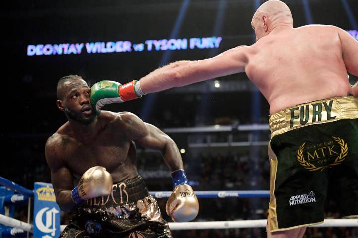 Tyson Fury, right, of England, connects with Deontay Wilder during a WBC heavyweight championsh ...