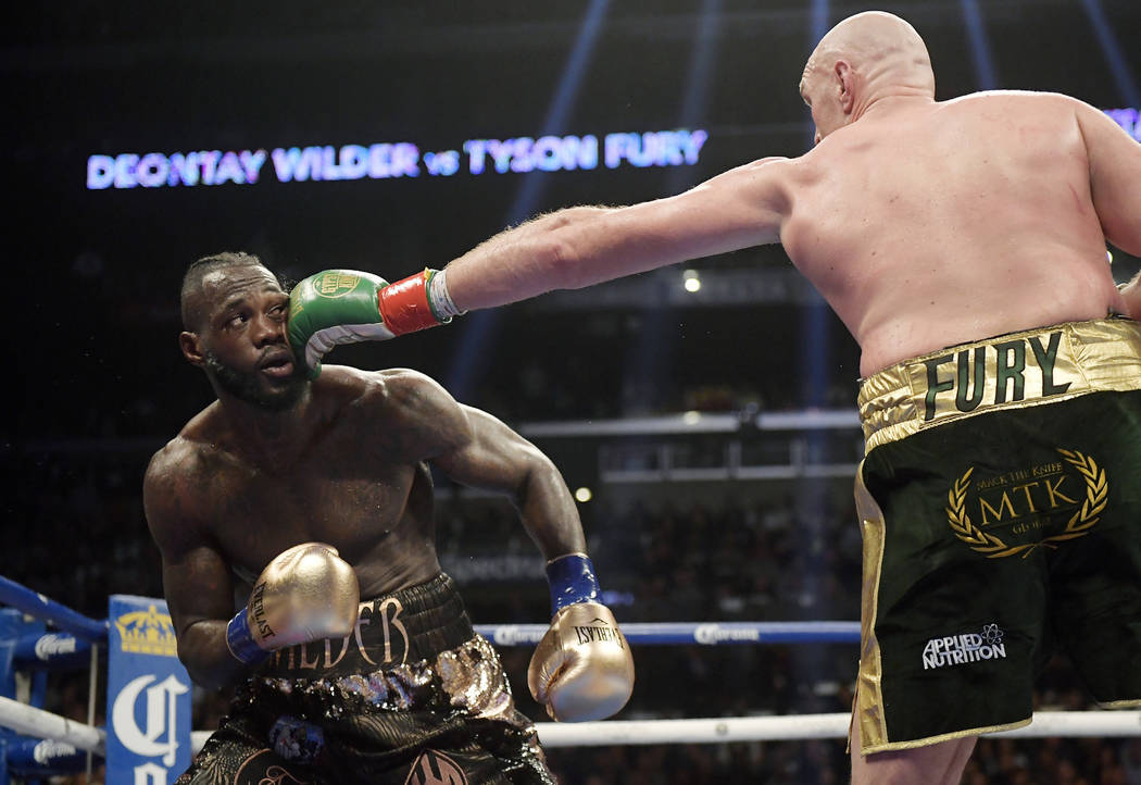 Tyson Fury, right, of England, connects with Deontay Wilder during a WBC heavyweight championsh ...