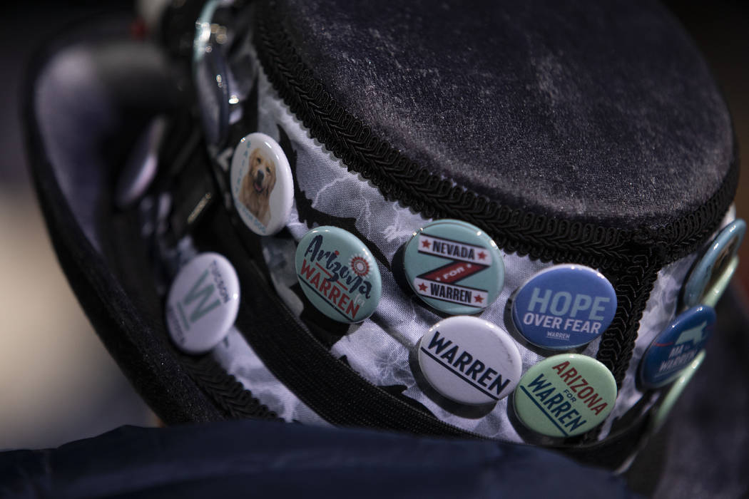 An Elizabeth Warren supporter wears a campaign button clad hat at the "Get Out the Caucus ...