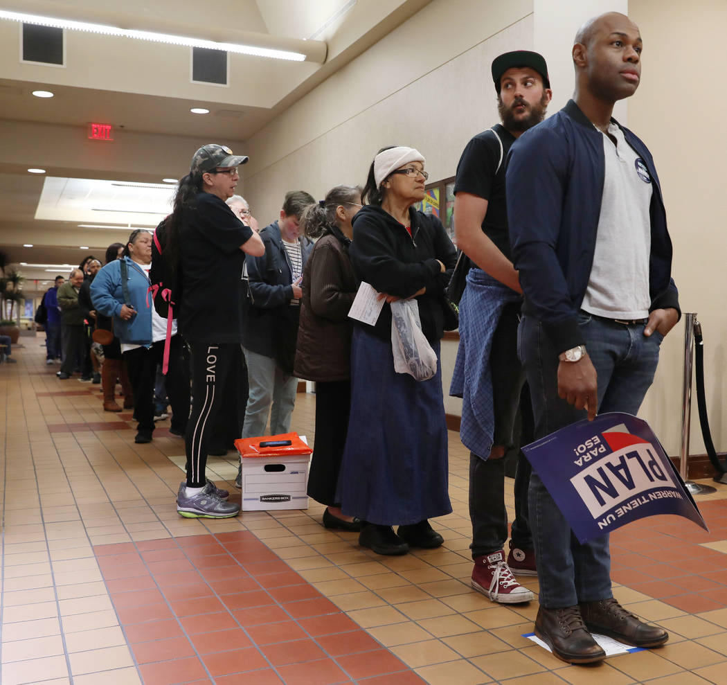 Individuals wait in line to register to caucus at the East Las Vegas Community Center in Las Ve ...