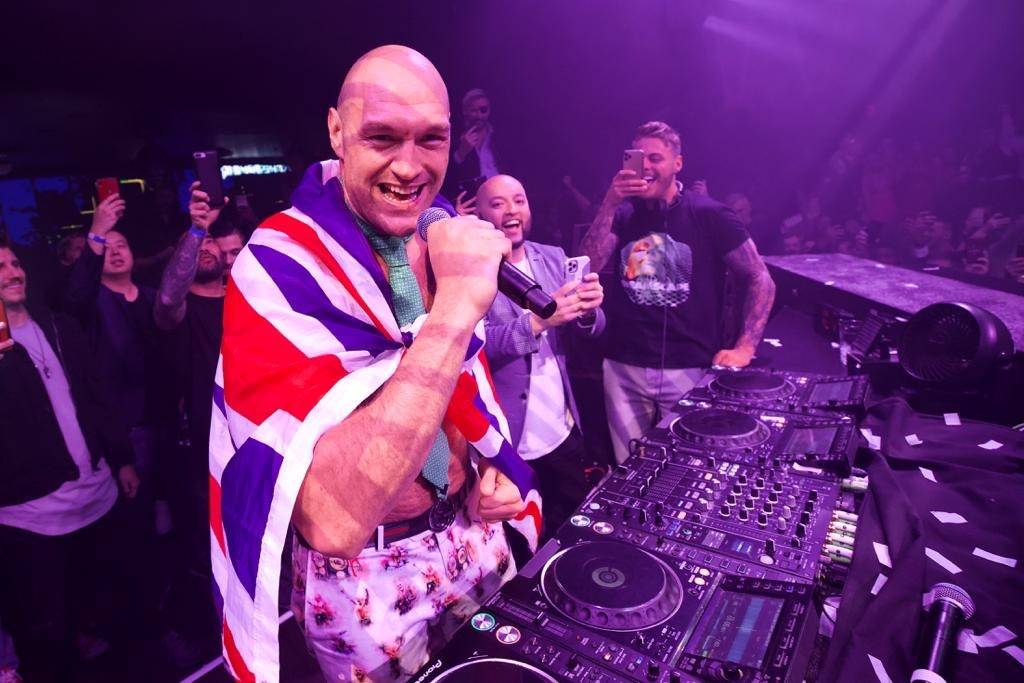 Tyson Fury (center, in Union Jack cape) is shown celebrating his seventh-round TKO victory over ...