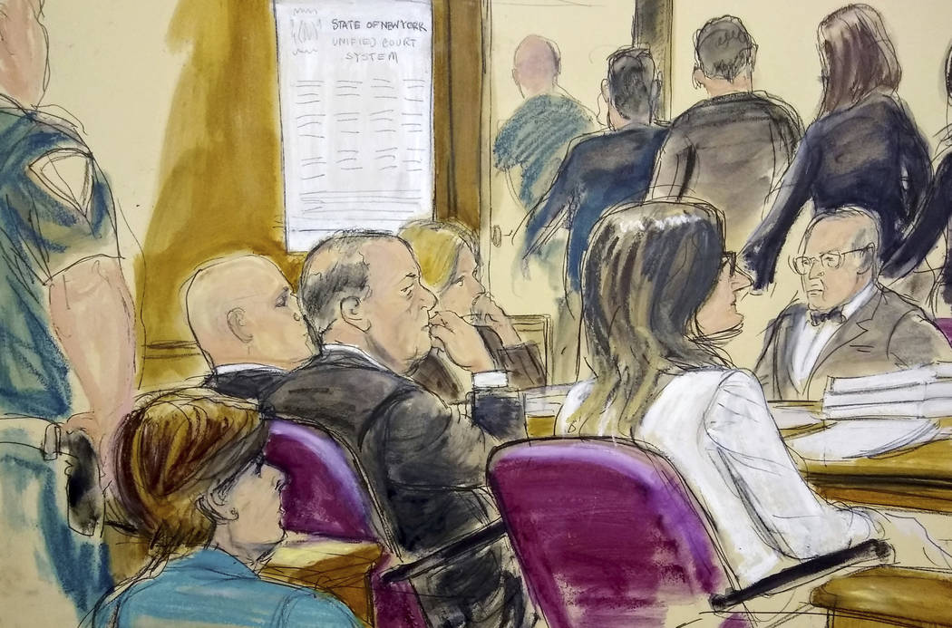 In this courtroom drawing, Harvey Weinstein, center, sits at the defense table surrounded by hi ...