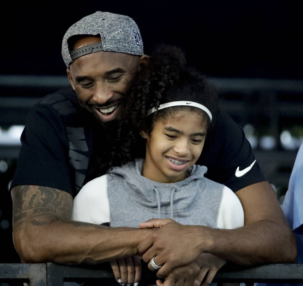 Former Los Angeles Laker Kobe Bryant and his daughter Gianna watch during the U.S. national cha ...