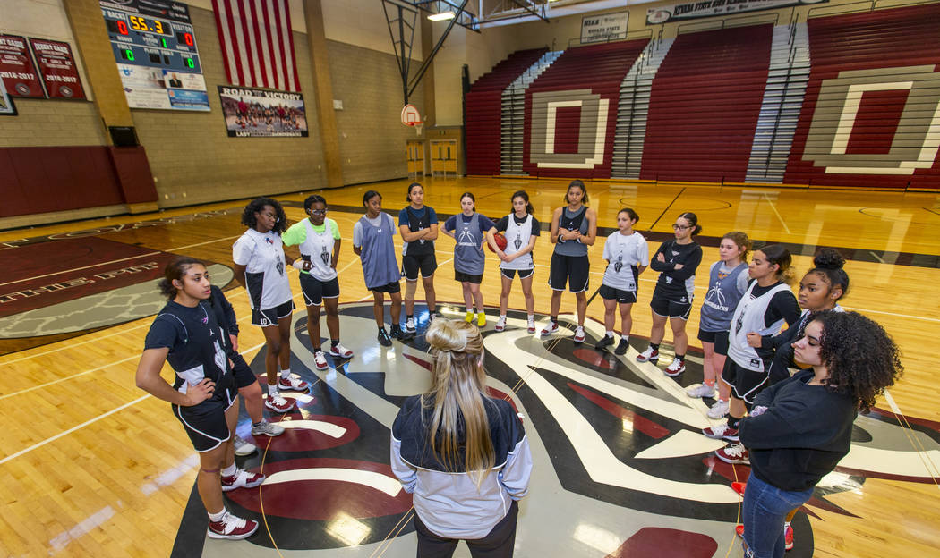 Head coach Laurie Evans, center, talks to her players during a Desert Oasis girl's basketball t ...