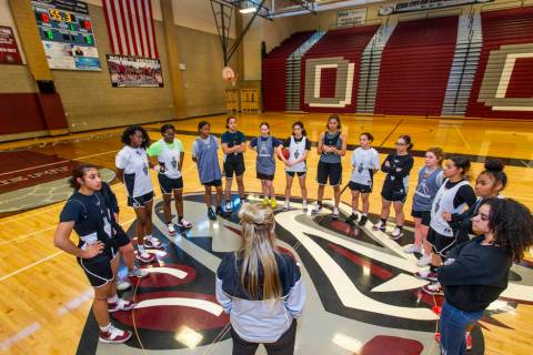 Head coach Laurie Evans, center, talks to her players during a Desert Oasis girl's basketball t ...
