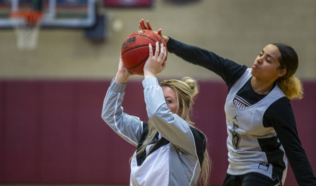 Head coach Laurie Evans, left, holds the ball tight as player Olivia Bigger attempts to swat it ...