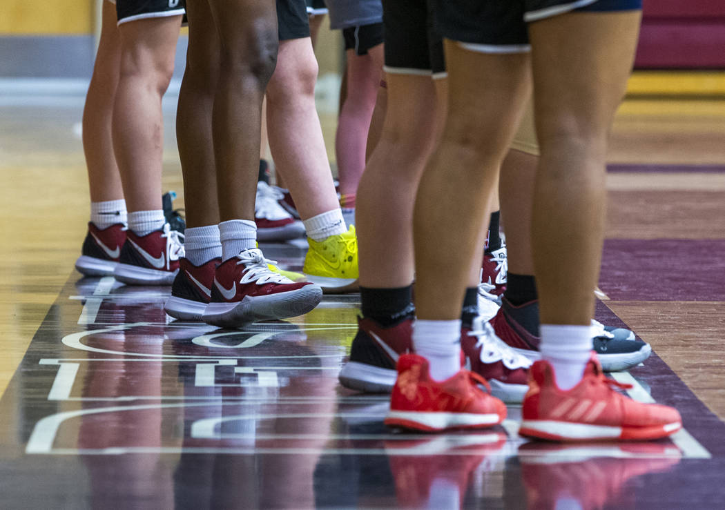 Desert Oasis girl's basketball team players stand on the base line and listen to instructions b ...
