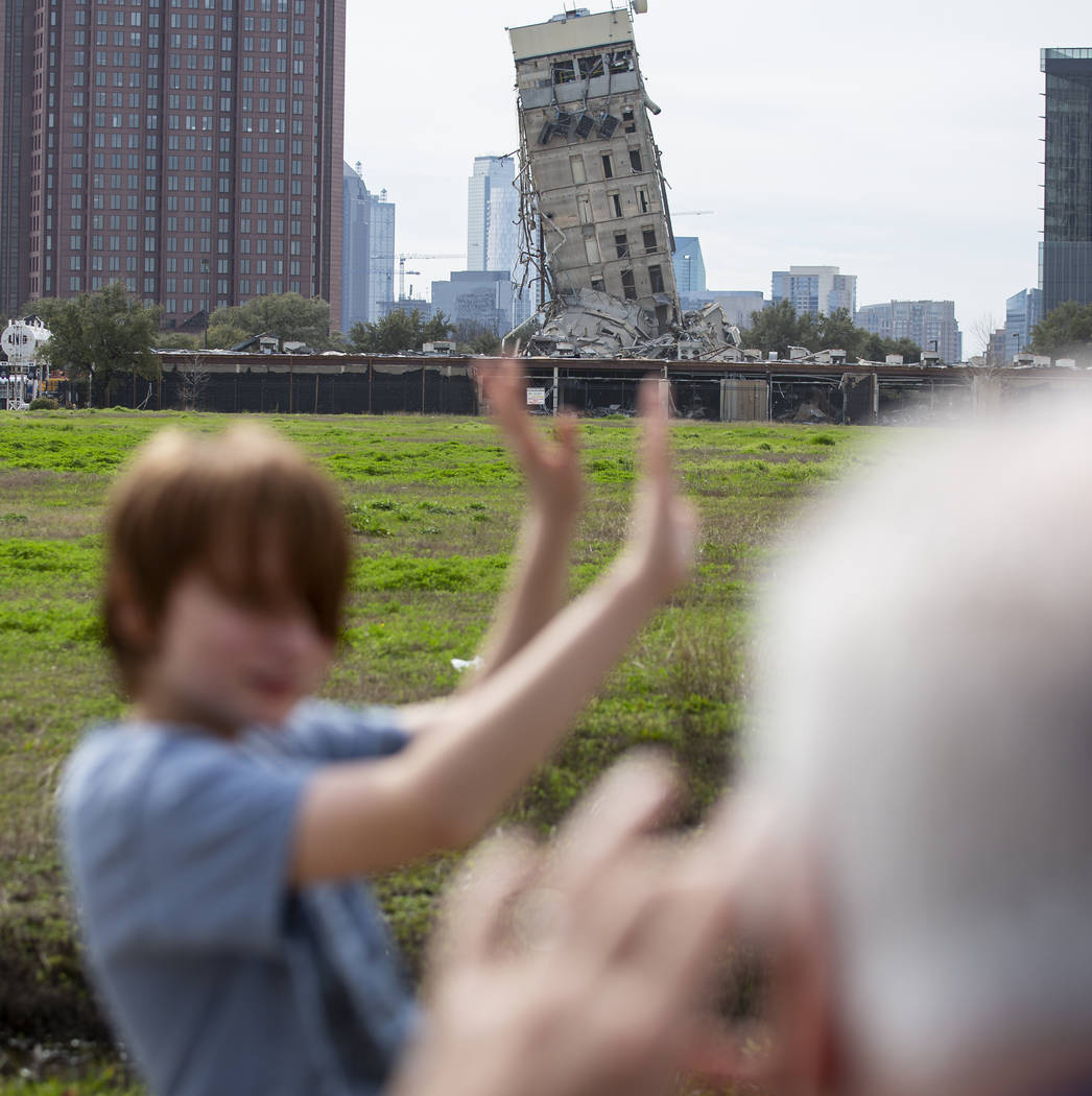 Randy Gibson takes a photo of his son Andrew, 11, in front of the 'Leaning Tower of Dallas' on ...