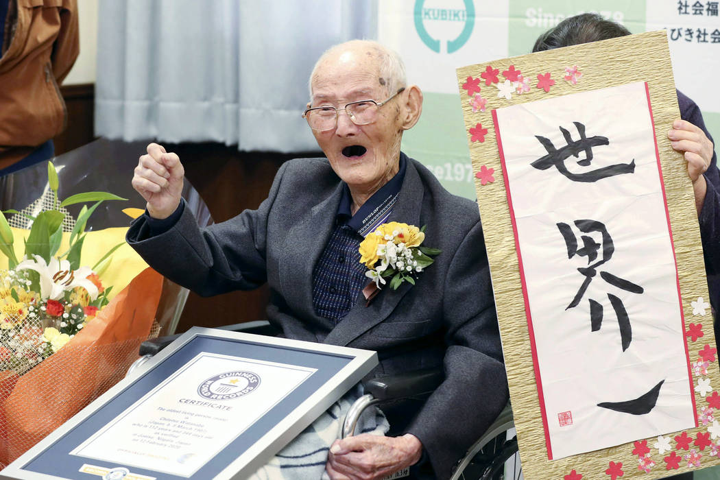 In this Feb. 12, 2020, file photo, Chitetsu Watanabe, 112, poses next to the calligraphy he wro ...