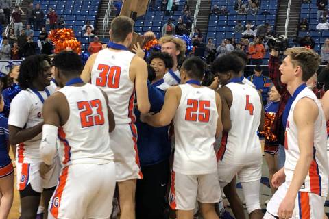 Bishop Gorman players celebrate with the championship trophy after defeating Desert Pines 65-37 ...