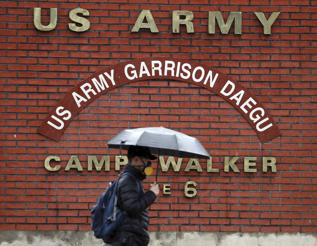 In this Tuesday, Feb. 25, 2020, photo, a man passes by U.S. Army base Camp Walker, in Daegu, So ...
