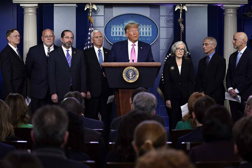 President Donald Trump with members of the president's coronavirus task force speaks during a n ...