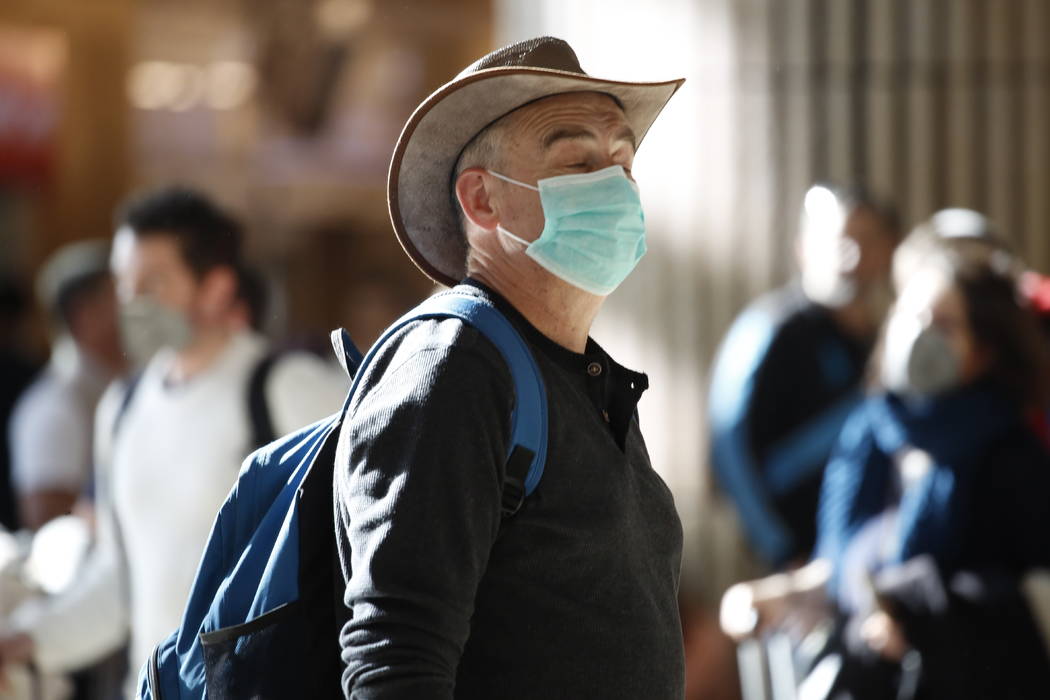 A man wearing a protective mask waits at the arrival hall in Ben Gurion Airport near Tel Aviv, ...