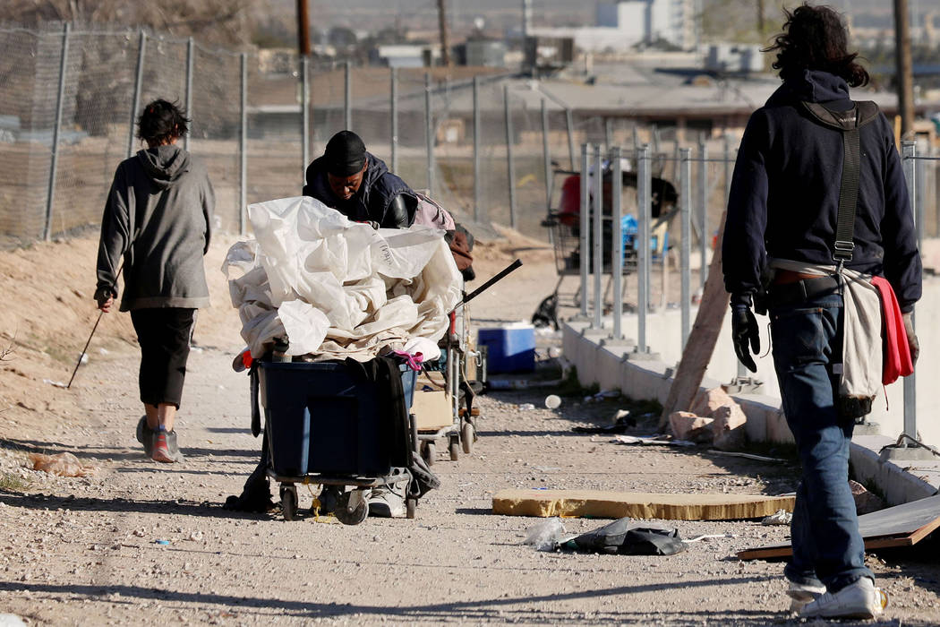 Individuals walk in a homeless community at the intersection of B Street and Owens Avenue in La ...