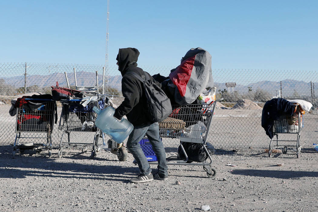 An individual walks in a homeless community at the intersection of B Street and Owens Avenue in ...