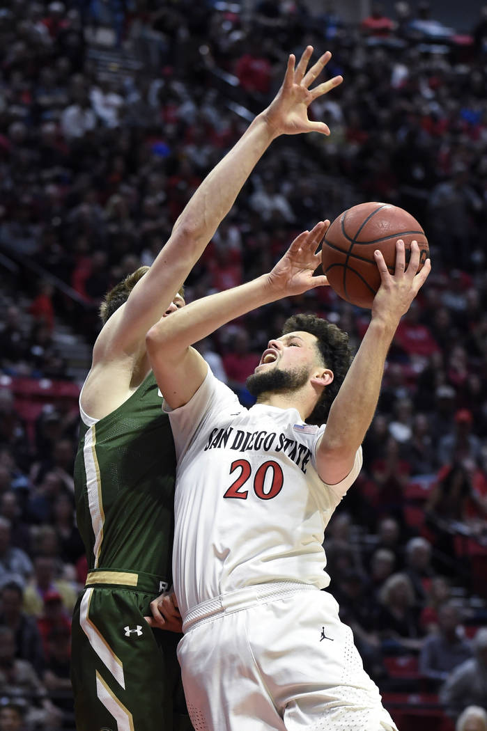 San Diego State guard Jordan Schakel (20) shoots as Colorado State forward Adam Thistlewood def ...