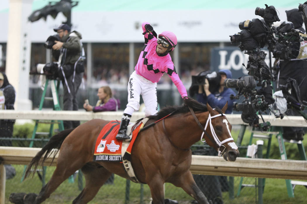 Luis Saez rides Maximum Security, and celebrates after crossing the finish line first during th ...