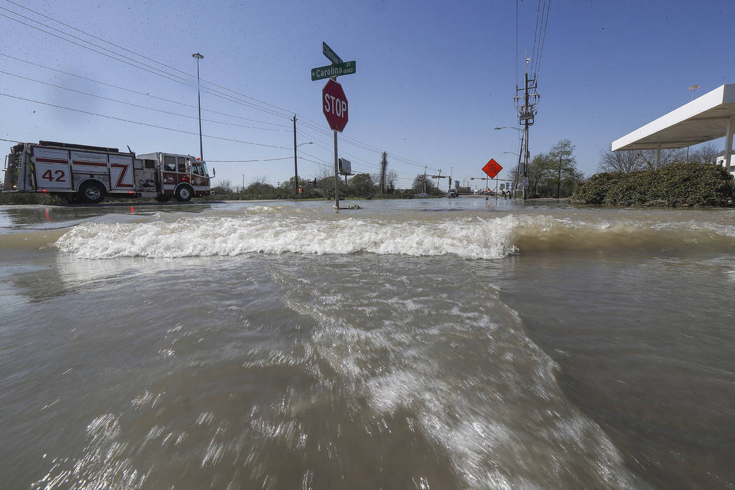 Water rushes by a gas station at Clinton and N. Carolina after a broken water pipe starting flo ...