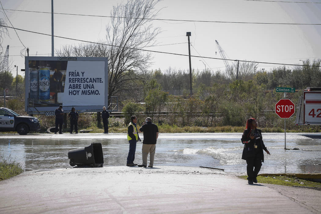 Water rushes by a gas station at Clinton and N. Carolina in Houston after a broken water pipe s ...