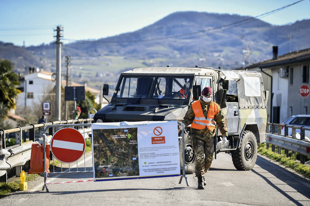 An Italian army soldier blocks off a road leading to the village of Vo'Euganeo, in Italy's nort ...