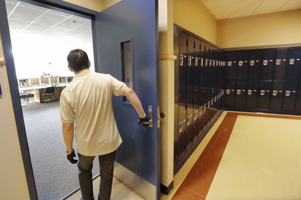 A school janitor opens the door to a staff room inside Bothell High School, closed for the day, ...