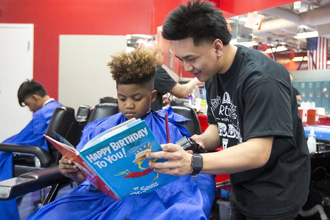 Barber student Tristian de Guzman reads to Nicholas Lewis, 12, during the third annual "Re ...