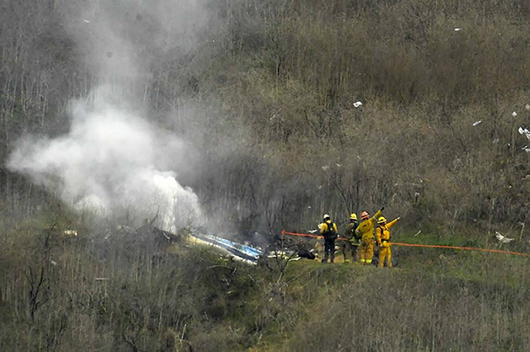 In this Jan. 26, 2020 file photo firefighters work the scene of a helicopter crash where former ...