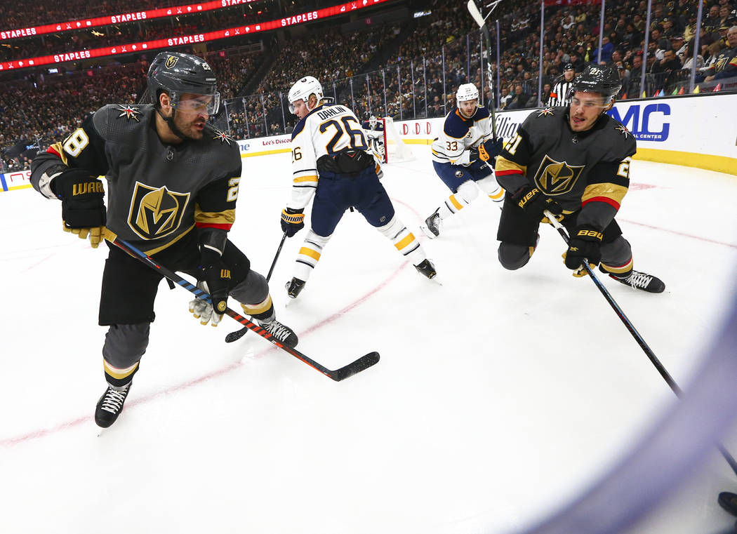 Golden Knights' William Carrier (28) and Nick Cousins (21) manoeuvre the puck around Buffalo Sa ...