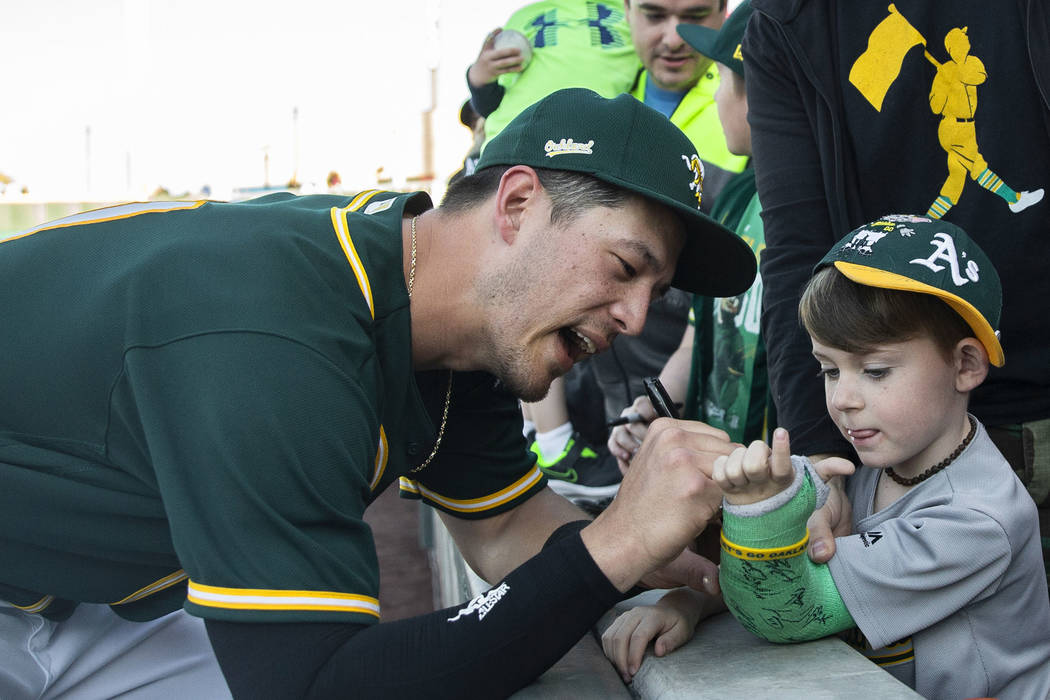 Oakland Athletics catcher Collin Theroux, left, signs the cast of Charleston Kenton, 6, at the ...