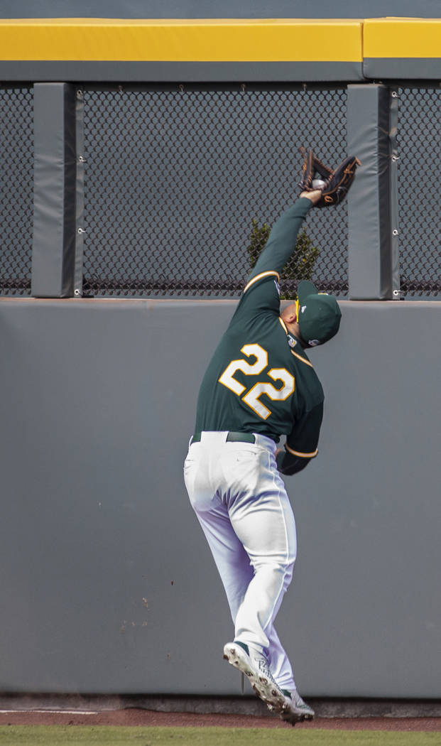 Oakland Athletics center fielder Ramon Laureano (22) makes a leaping catch at the wall in the t ...