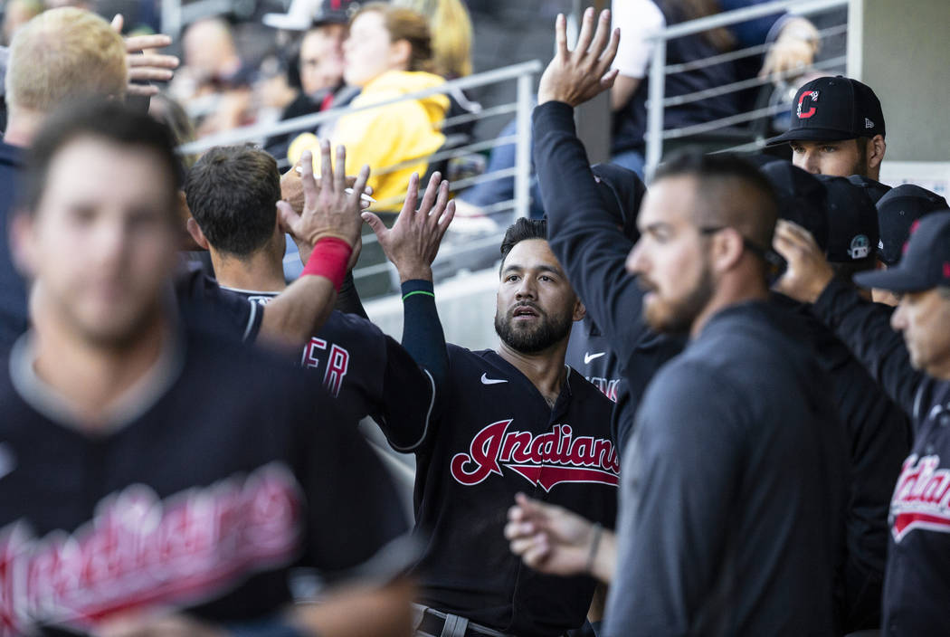 Cleveland Indians outfielder Ka'ai Tom, middle, celebrates with teammates after scoring in the ...