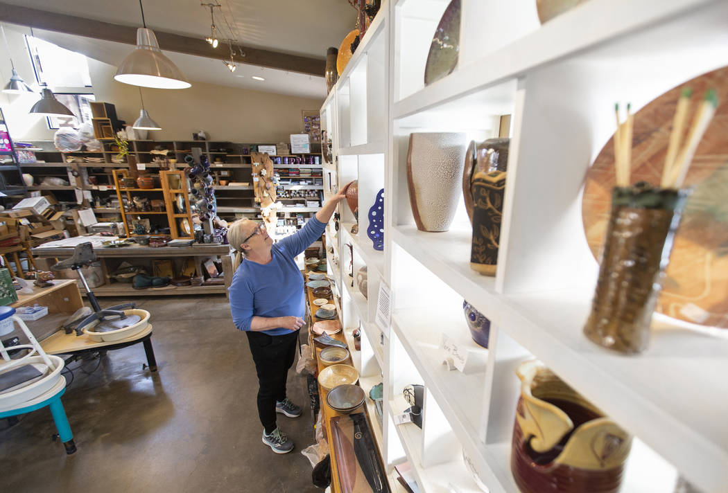 Kathy Barth reaches for a vase at the Zia Pottery Gallery in Kayenta Art Village. (Benjamin Hag ...