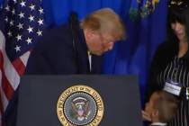 President Donald Trump leans over to talk to 7-year-old Jamel as Jamel's mother, Lois Hockersmi ...