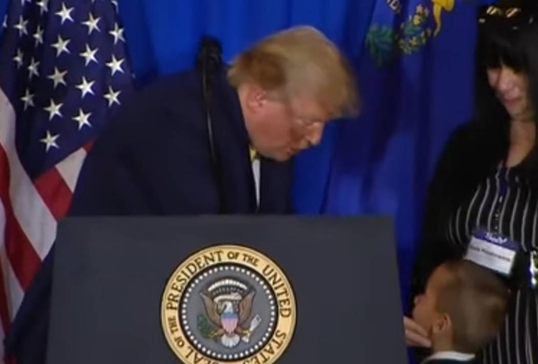 President Donald Trump leans over to talk to 7-year-old Jamel as Jamel's mother, Lois Hockersmi ...