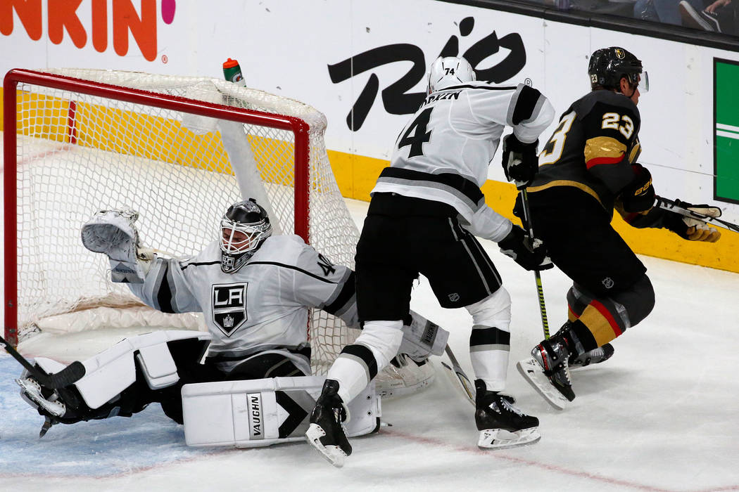 Vegas Golden Knights defenseman Alec Martinez (23) tangles with Los Angeles Kings goaltender Ca ...