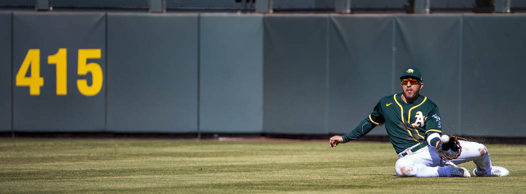 Oakland Athletics outfielder Ramon Laureano (22) makes a sliding catch over the Cleveland India ...