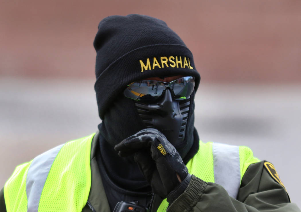 Deputy Marshal David Buhr is bundled up as he crosses Clark Avenue during windy morning on Mond ...