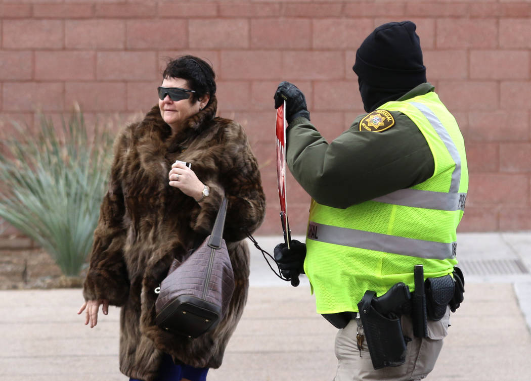 Deputy Marshal David Buhr helps District Judge Elizabeth Gonzalez cross Clark Avenue ...