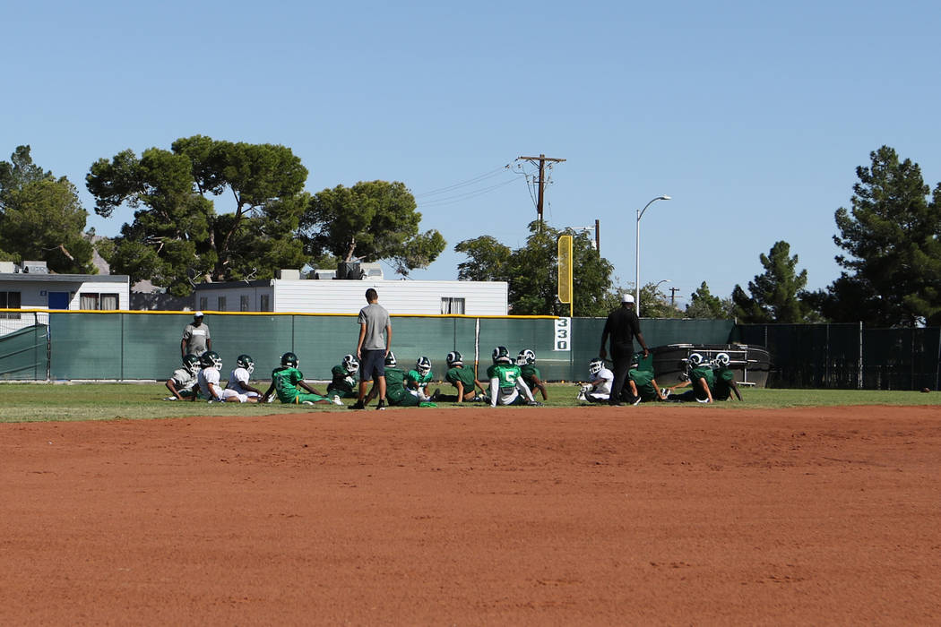 The Rancho High School football team stretches in the outfield of the school's baseball field i ...