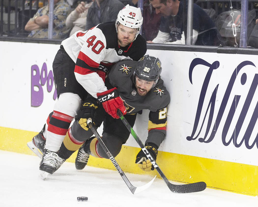 Vegas Golden Knights center Chandler Stephenson (20) collides with New Jersey Devils defensemen ...