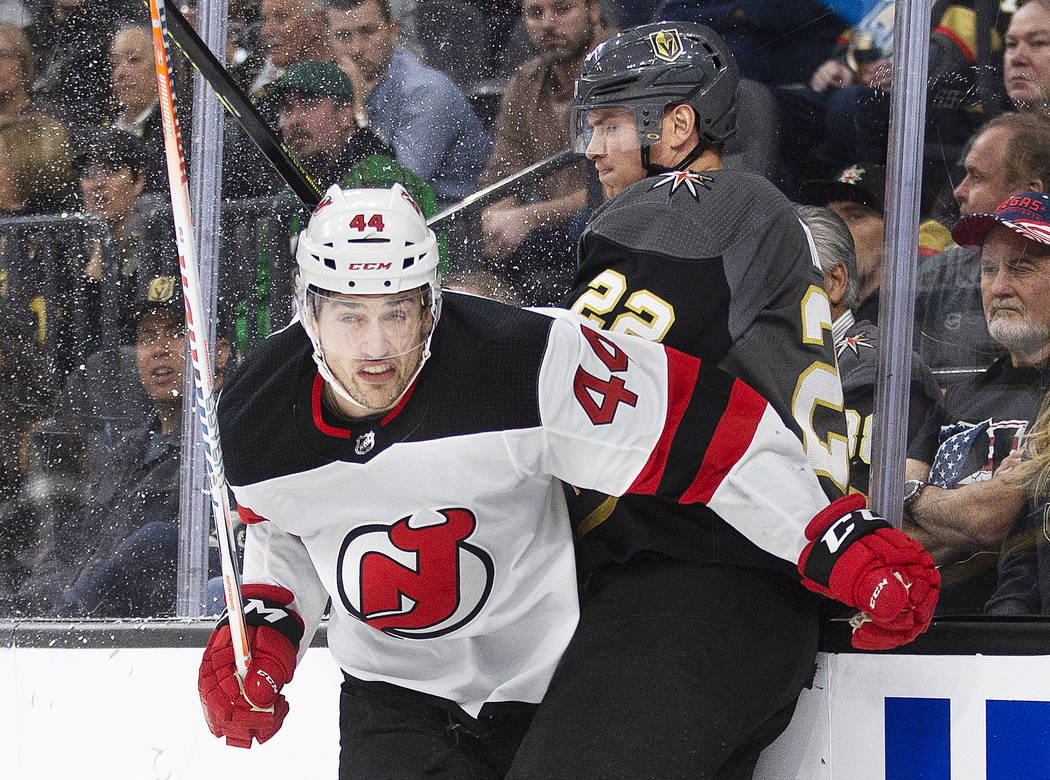 New Jersey Devils left wing Miles Wood (44) hits the boards with Vegas Golden Knights defensema ...